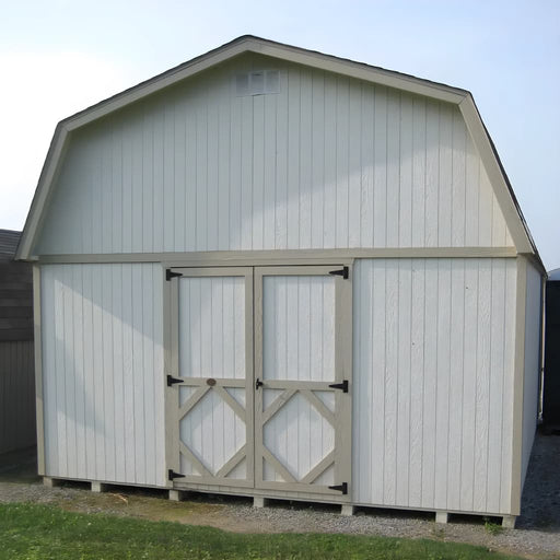 White little cottage co large gambrel barn roof and double doors on a clear day.