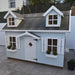 Light blue palmako 9x6 marie children's playhouse with white accents on a concrete patio