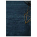 Partial view of the Midnight Blue hand-knotted wool rug styled beside a chair