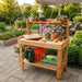 Outdoor Living Today 4x2 Cedar potting bench with gardening tools and supplies in a garden setting