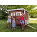 Classic red OverEZ Large Chicken Coop with three children and chickens in a sunny yard.