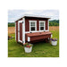 Classic red OverEZ Large Chicken Coop installed in a field with potted flowers.