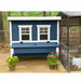 Blue Coastal OverEZ Large Chicken Coop beside a run with potted flowers.