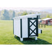 Farmhouse OverEZ Large Chicken Coop side view with barn-style man door in a field.