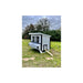White and dark-trim Farmhouse OverEZ Large Chicken Coop installed in a grassy yard.