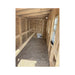 Unfinished wood coop interior showing roost bars, OSB wall panels, a gravel floor, a small chicken door, and a side window.