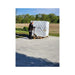 Wrapped OverEZ XL chicken coop shipping pallet on a driveway beside a person using a pallet jack.
