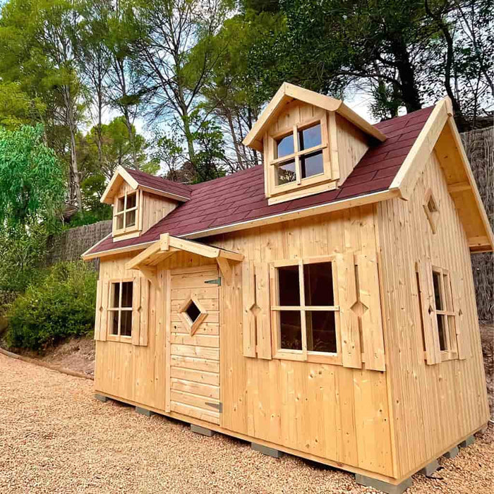 Wooden palmako marie 6x9 playhouse with dormer windows in a natural setting