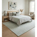 Blue and ivory area rug placed beneath a bed in a bedroom