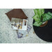 Styled blue and ivory rug with a book, plant, and round dark table
