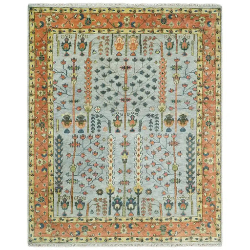 Front view of the full rectangular Rust and Blue Tree of Life rug on white with a pale blue-gray field, rust border, and fringe