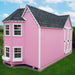 Pink Little Cottage Co. Sara's Victorian Playhouse Kit with a gray roof on a grassy area