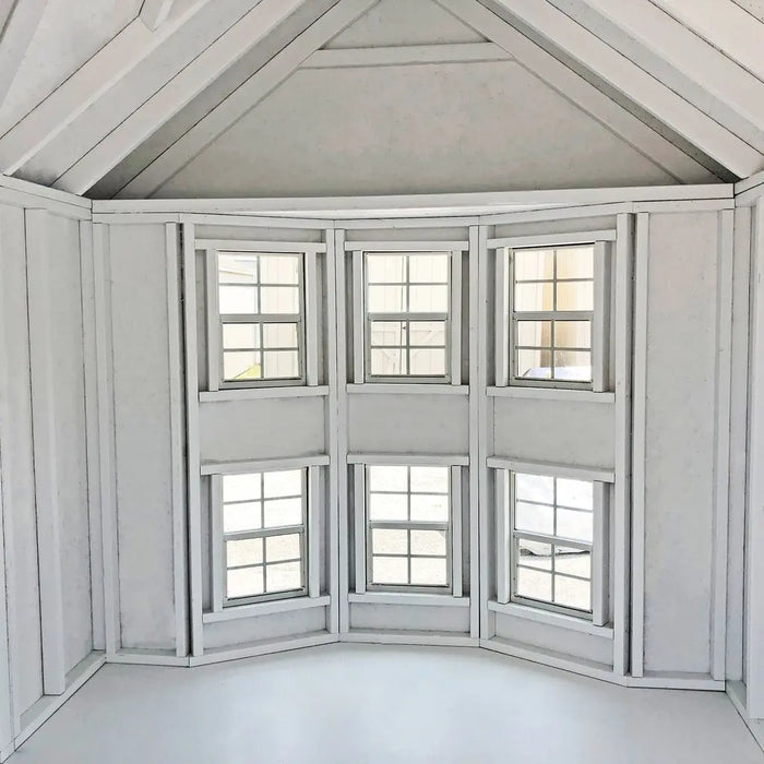 Little Cottage Co. Sara's Victorian Playhouse Kit, corner window design with multiple panes in a room with white walls and ceiling.