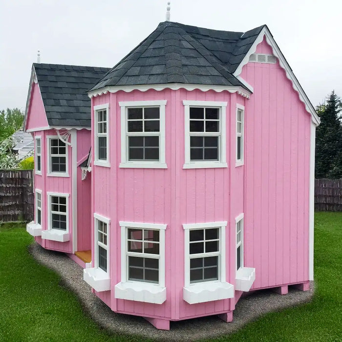 Pink Little Cottage Co. Sara's Victorian Playhouse Kit with white trim on a grassy area