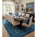 Blue rectangular rug beneath a dining table in a furnished room, with table and furnishings not included