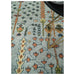 Top-down partial view of the rug field and Tree of Life botanical motifs beside a furniture edge