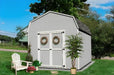 Value Gambrel Barn with 6 Sidewall - in a Garden with plants and trees